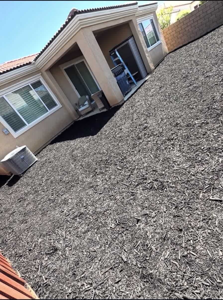 Freshly installed decorative mulch bed alongside a home